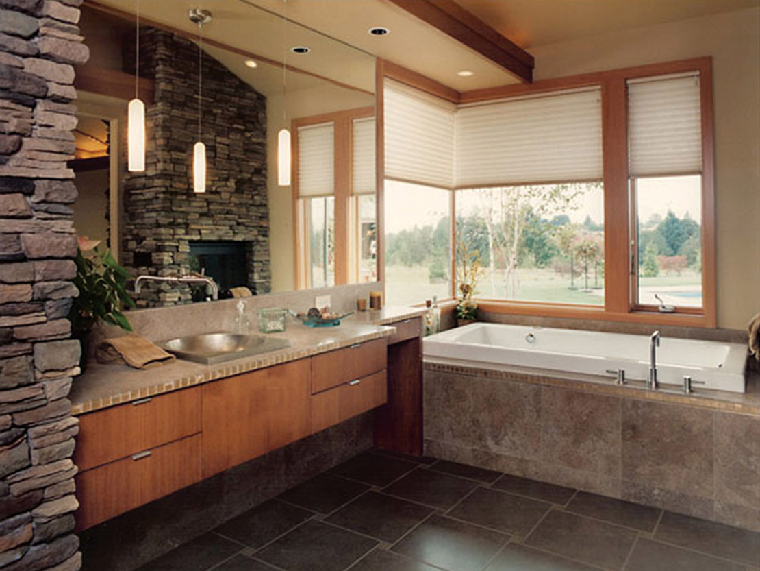 Stone-accent bathroom with soaking tub by CM&D